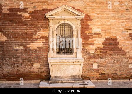 Kleiner Flügelaltar auf einem Haus in Venedig (Italien) Stockfoto