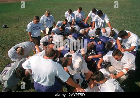 San Marcos, TX: Fußballmannschaft an der privaten Baptist-Highschool betet vor dem Training. ©Bob Daemmrich Stockfoto