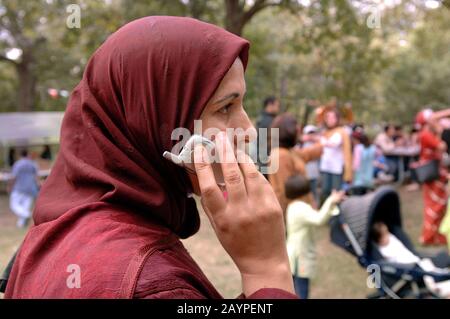 Austin, Texas 12. November 2005: Marokkanische Frau am Handy am Ende des Ramadan (Eid) Festivals, wo die muslimische Gemeinschaft von Zentral-Texas begrüßt alle Glaubensrichtungen zu einem Treffen präsentiert Essen, Tanz und Feste der muslimischen Welt, ©Bob Daemmrich Stockfoto