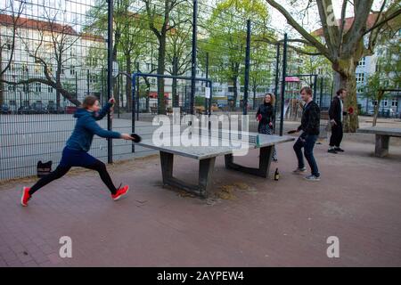 Die Jugend spielt Tischtennis im Berliner Innenhof. Dynamischer Moment - verschwommene Bewegung! Lächelnde junge Frau und Mann Stockfoto