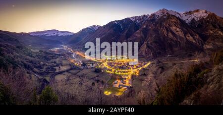 Schöne kleine Dorflandschaft bei Sonnenuntergang mit schneebedeckten Bergen, Hintergrund bei Nacht im Winter, Benasque, Aragonese Pyrenäen, Spanien Stockfoto