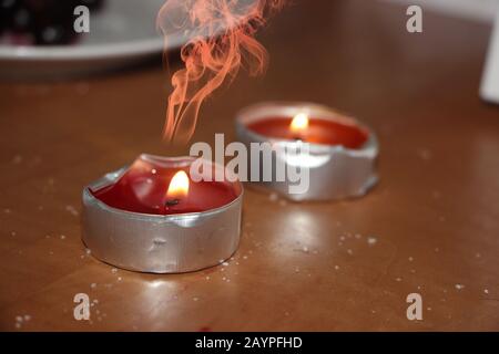 Zwei rote brennende Kerzen, mystische rote kerzen und Zucker auf dem Tisch Stockfoto