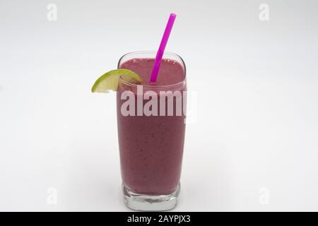 Beere Smoothie mit Strohhalm- und Kalkgarnierstudio, weißer Hintergrund Stockfoto