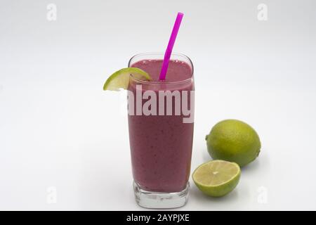 Beere Smoothie mit Strohhalm- und Kalkgarnierstudio, weißer Hintergrund Stockfoto
