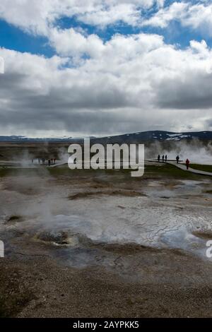 Die Menschen laufen auf Spaziergängen durch die heißen Quellen bei Hveravellir, einem geothermischen Gebiet mit Fumarolen und bunten heißen Pools im zentralen Hig Stockfoto