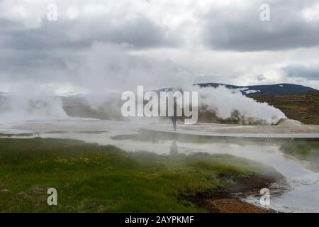 Die Menschen laufen auf Spaziergängen durch die heißen Quellen bei Hveravellir, einem geothermischen Gebiet mit Fumarolen und bunten heißen Pools im zentralen Hig Stockfoto