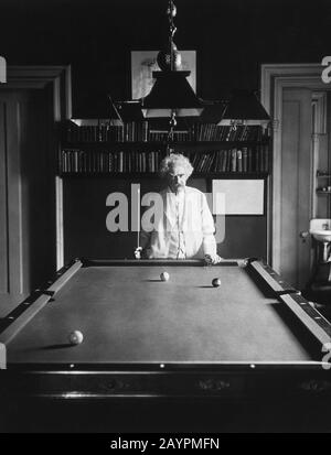 Vintage-Foto des amerikanischen Schriftstellers und Humoristen Samuel Langhorne Clemens (zwischen den Jahren von 30-10), besser bekannt unter seinem Federnamen Mark Twain, der an einem Pool-/Billardtisch mit einem Stichwort in der Hand steht. Foto ca. 1908 von Underwood & Underwood. Stockfoto