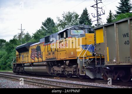 Elburn, Illinois, USA. Eine Union-Pacific-Lok fungiert als Helfereinheit am Hinterende, die einen Zug mit leeren Kohlehopfen treibt. Stockfoto