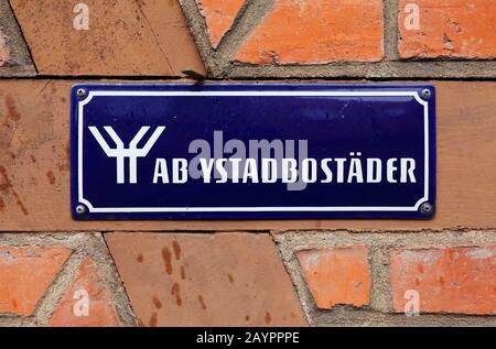 Ystad, Schweden - 15. April 2017: Das Schild mit dem Grundstückseigentümer ab Ystadbostader ist an der roten Ziegelmauer angebracht. Stockfoto