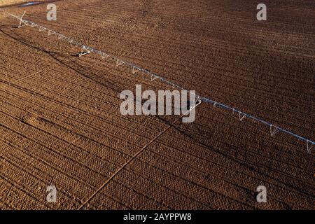 Luftbild des Mittenpivotbewässerungssystems auf gepflügten Feldern aus Drohnenpov, Landwirtschaft und landwirtschaftlichen Geräten Stockfoto