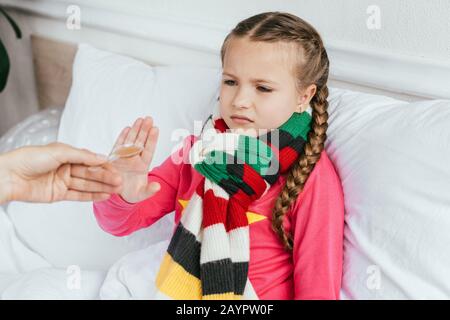 Traurige erkrankte Tochter im Schal will keine Medikamente nehmen Stockfoto