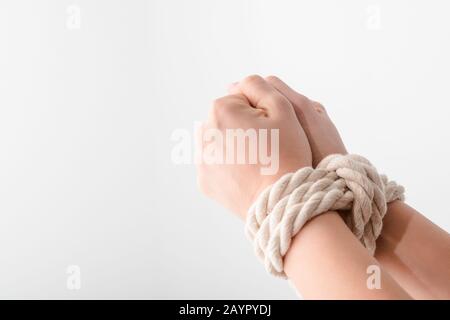 Beschnittenes Bild von Frau mit gefesselten Händen isoliert auf weißem Menschenrechtskonzept Stockfoto