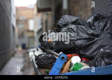Überströmte City Trash Dose in einer Schmutzigen Gasse Stockfoto