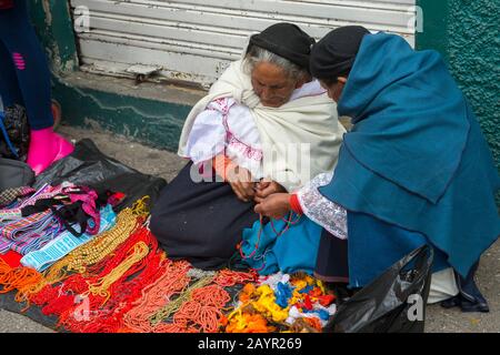Eine lokale Frau verkauft Halsketten auf dem lokalen Markt in der Stadt Otavalo im Hochland Ecuadors bei Quito. Stockfoto