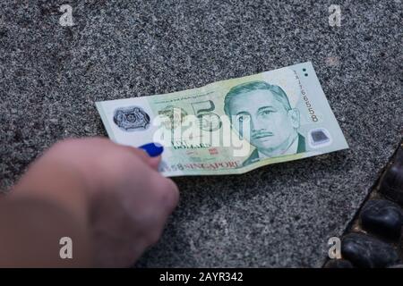 Eine 5-Dollar-Note in Singapur in grüner Farbe auf dem Boden. Stockfoto