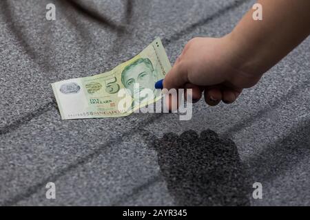 Eine grüne Währung für fünf Dollar in Singapur auf dem glänzenden Boden. Stockfoto