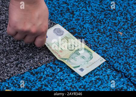 Eine 5-Dollar-Note in Singapur in grüner Farbe auf dem Boden. Stockfoto