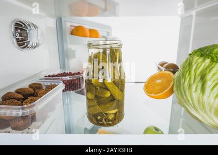 Mixbecher mit Kohlkopf, Früchten und Schnürsenkeln im Kühlschrank mit offener Tür, isoliert auf weißem Stockbild Stockfoto