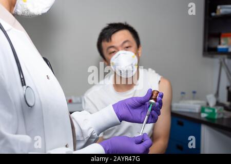 Chinesische Männer, die im Krankenhaus Impfstoff und Behandlung erhalten Stockfoto