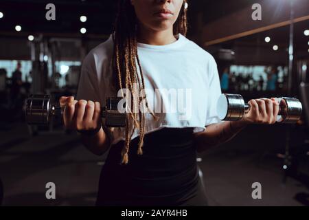 3/4-Ansicht der afroamerikanischen Frau, die Hanteln hebt Stockfoto