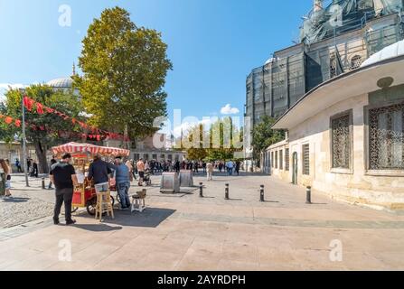 Lokale Türken genießen einen sonnigen Tag und gegrillten Mais in der Innenstadt von Istanbul Türkei in der Nähe von Eminonu und Basar. Stockfoto