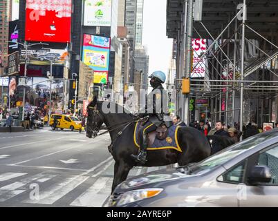 Die auf einem Pferd aufgestellte Polizeifrau der New Yorker Polizei geht über die 7th Avenue am Times Square, Manhattan, New York City Stockfoto