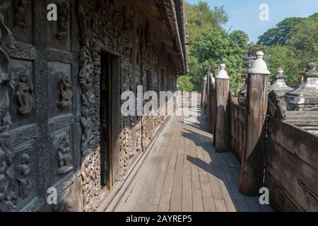 Ein Außengang mit Holzschnitzereien aus Teakholz im Kloster Shwenandaw (Kloster Goldener Palast) in Mandalay Hill, das im Jahr 1880 von King Th erbaut wurde Stockfoto