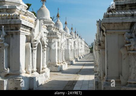 Stupas-Reihen, die jeweils eine der 729 Platten enthalten, die mit den buddhistischen Lehren auf der Kuthodaw-Pagode auf dem Mandalay-Hügel, Mandalay, Myanmar, eingraviert sind. Stockfoto