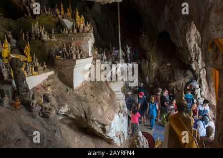 Touristen in der Tham Ting (untere Höhle) der Pak Ou Caves, die in einem Kalksteingebirge oberhalb des Mekong Flusses bei Luang Prabang in Zentral-Laos liegt Stockfoto