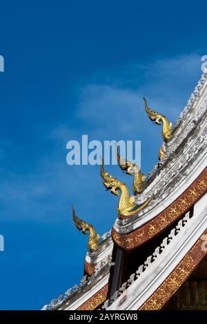 Detail des mehrstufigen Dachs, das mit stilisierten Naga-Finalen an den Dachenden auf dem Haw Pha Bang (dem Königlichen Tempel) am Royal Pal verziert ist Stockfoto