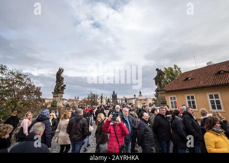 Prag, TSCHECHIEN - 1. NOVEMBER 2019: Karlsbrücke (Karluv Most) oder staromestska mostecka vez Turm voller Touristen, einige fotografieren Stockfoto