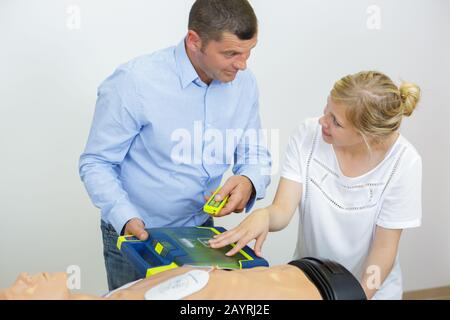 Gesundheitsfachkraft im Training mit Herzdefibrillator zur Attrappe Stockfoto