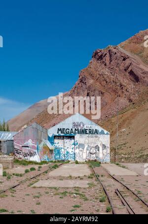 Mendoza, ARGENTINIEN - 17. NOVEMBER 2019: Vertikaler Schuss von Wandbild in der alten Station mit "Nein zum Bergbau"-Botschaft und Bergen in der Backgroundlage neben "Pu Stockfoto