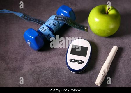 Nahaufnahme von diabetischen Messgeräten und apfel auf dem Tisch Stockfoto