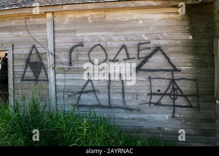 Graffiti an einer Wand eines verlassenen alten Gehöfts zerfallen langsam in der Nähe von Pullman im Whitman County in der Palouse, Washington State, USA. Stockfoto