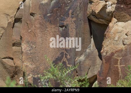 Alte Petroglyphen von Menschen wie Figur sind in Sandsteinfelsen gehauen, die im Laufe der Zeit am Legend Rock State Petroglyph Site reißen und brechen Stockfoto