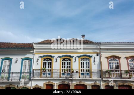 Niedriger Winkelschuss von Häusern im farbenfrohen Kolonialstil mit einem portugiesischen Einfluss im Stil des Barock in Ouro Preto, Brasilien. Ouro Preto wurde zum Weltkulturerbe Si Stockfoto