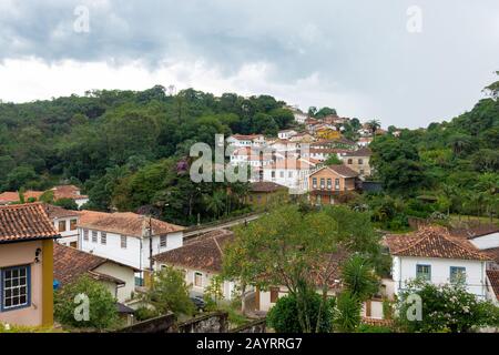 Ouro PRETO, MINAS GERAIS, BRASILIEN - 22. DEZEMBER 2019: Häuser im Kolonialstil im Berg mit "Agua Limpia"-Nachbarschaft im Hintergrund. Ouro P Stockfoto