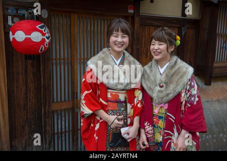 Junge Frauen kleideten sich in Kimonos in einer kleinen Straße im historischen Gion District von Kyoto, Japan. Stockfoto