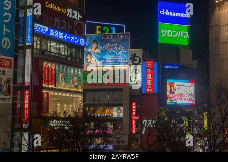 Sehen Sie sich nachts die farbenfrohen Anzeigen auf der Shibuya Station in Tokio, Japan an. Stockfoto
