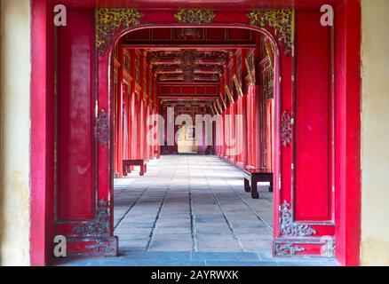 Symmetrischer Korridor und rote Türen in der Verbotenen Purpurstadt, Dem Historischen Kaiserpalast und dem Welterbe der Vereinten Nationen in Hue, Vietnam Stockfoto