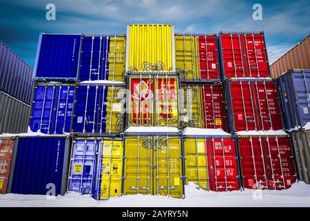 Die Nationalflaggen Andorras auf einer großen Anzahl von Metallbehältern zur Lagerung von Waren, die in Reihen übereinander gestapelt sind. Konzeption der Lagerung von g Stockfoto