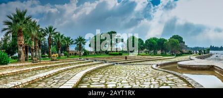 Ein Pfad in einem kleinen Park mit Aussichtsplattform auf dem weißen Pamukkale Berg in der Nähe von Travertinen an einem Sommermorgen. Stockfoto