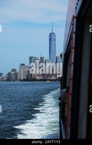 Blick zurück auf Das One World Trade Center und die Skyline von Manhattan von der Staten Island Ferry in Upper Bay, Seite der Fähre und wachwasser im Blick Stockfoto