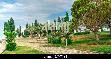 Ein Pfad in einem kleinen Park mit Aussichtsplattform auf dem weißen Pamukkale Berg in der Nähe von Travertinen an einem Sommermorgen. Stockfoto