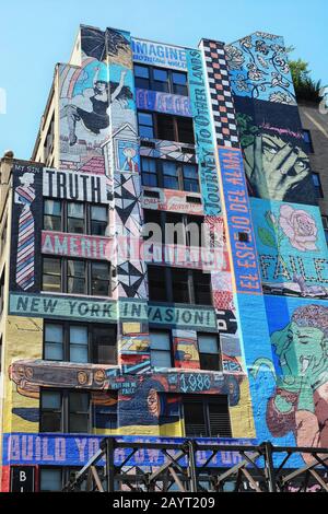 FAILE malte Wandgemälde auf einem Gebäude in der Nähe der 42. Straße von New york City, Bilder der Popkultur, Text und Grafik "American Education" "New york Invasion" Stockfoto