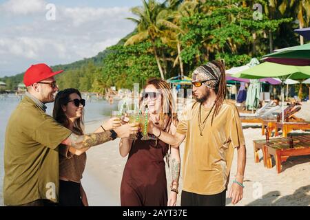 Fröhliche Freunde, die Strandparty genießen und mit einer Brille köstlicher Cocktails toben Stockfoto