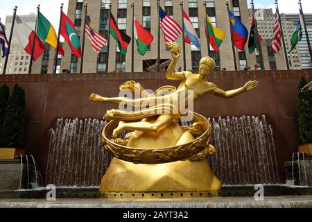 Schöne Art Deco Gold Prometheus Statue und bunte World Flags Flying, untere plaza des Rockefeller Center in Manhattan, New York City Stockfoto