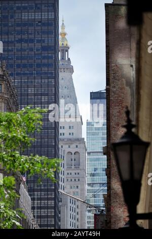 Ein Stück des Met Life Tower und es ist eine goldene Kuppel, die in einem langen Schuss entlang der Madison Avenue zu sehen ist, der von einem modernen Hochhaus und einer alten Straßenlampe umrahmt wird Stockfoto