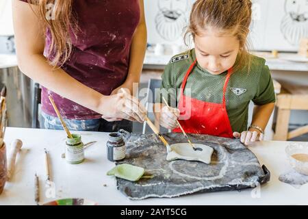 16. SEPTEMBER 2018, UFA, RUSSLAND: Mama und Tochter malen mit Brusha frisch zubereitetem Tonprodukt, Kunstkonzept und Handarbeit Stockfoto